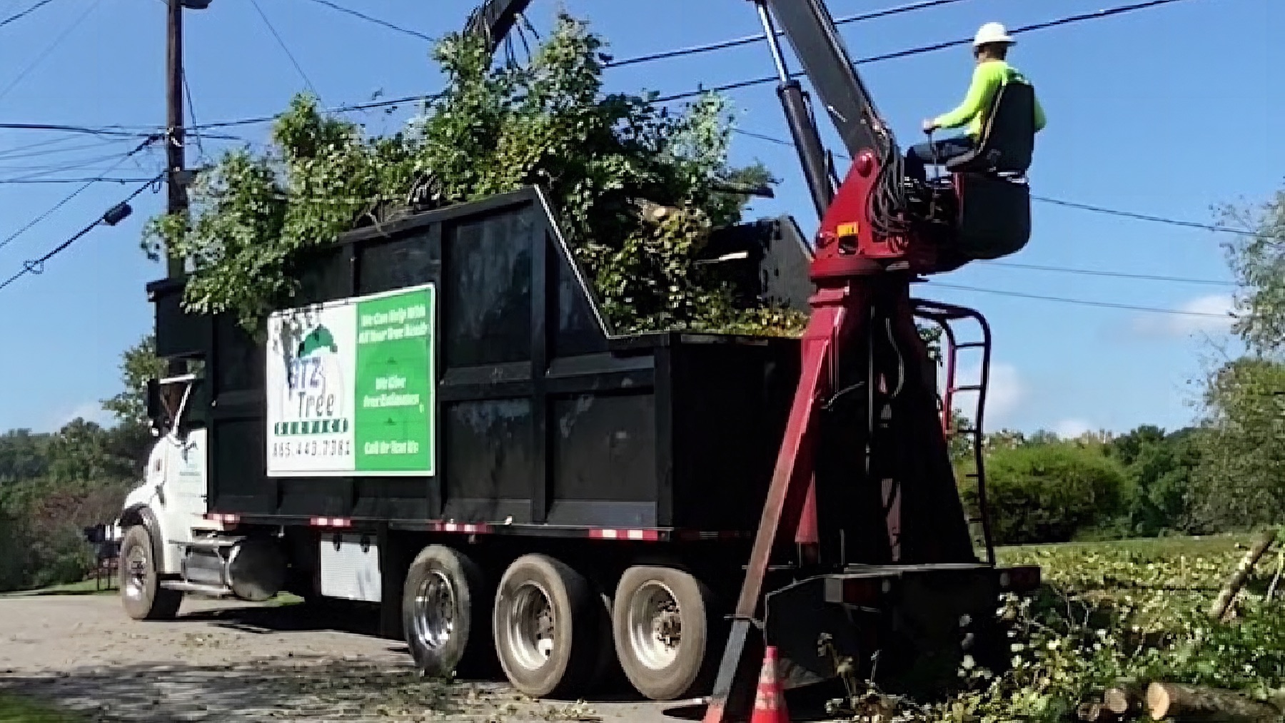 The GTZ Tree Service crew loading brush into the chip truck on a Knoxville street